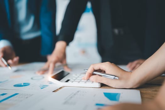 Accountant checking financial statement or counting by calculator income for tax form, Business woman sitting and working with colleague discussing the desk in office. Audit concept.