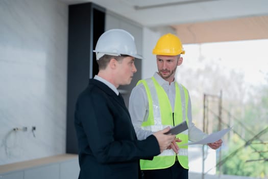 multi ethnic engineer brainstorming and measuring for cost estimating on blueprint and floor plan drawings about design architectural and engineering for houses and buildings.