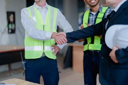 multi ethnic engineer brainstorming with deal and measuring for cost estimating on paperworks and floor plan drawings, contract and agreement concepts.