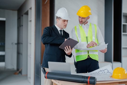 multi ethnic engineer brainstorming and measuring for cost estimating on blueprint and floor plan drawings about design architectural and engineering for houses and buildings.