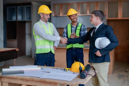 multi ethnic engineer brainstorming with deal and measuring for cost estimating on paperworks and floor plan drawings, contract and agreement concepts.