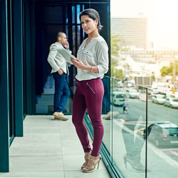 This tablet is a real time saving business tool. Portrait of a young businesswoman using a digital tablet at work