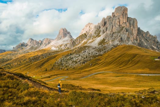 Tourist enjoying the exploration amidst the towering mountains of the famous Giau Pass