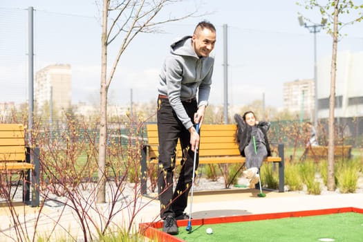 man playing mini golf. Summer season game.