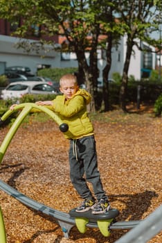 Funny cute happy baby playing on the playground. The emotion of happiness, fun, joy. Smile of a child. boy playing on the playground.