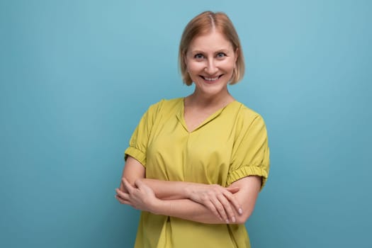 thoughtful blonde mature woman smiling and emotional on studio background.