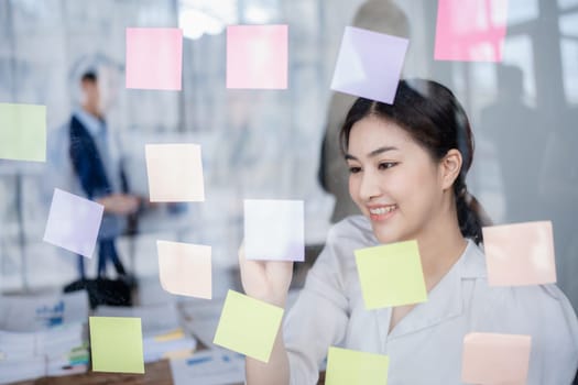 Beautiful young teen asian businesswoman using note pad thinking with planning working on financial document, tax, exchange, accounting and Financial advisor.