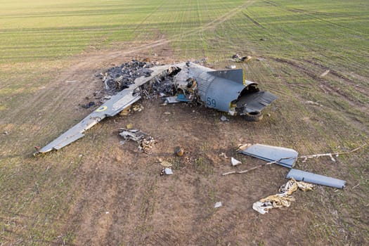 In this picture, an AN-26 aircraft can be seen lying on a field in Ukraine after an accident. The aircraft appears to have suffered significant damage, with parts scattered around the wreckage. The image conveys the severity of the accident and the potential dangers of aviation during the war