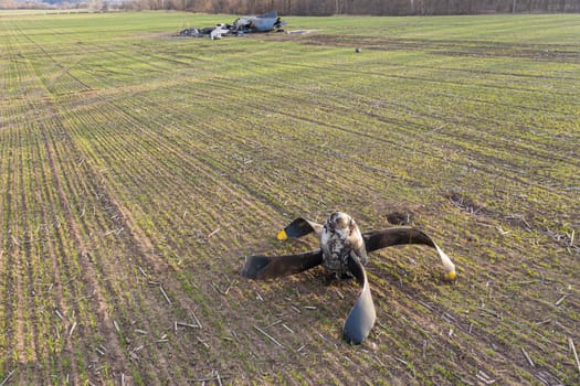 In this picture, an AN-26 aircraft can be seen lying on a field in Ukraine after an accident. The aircraft appears to have suffered significant damage, with parts scattered around the wreckage and propeller close-up. The image conveys the severity of the accident and the potential dangers of aviation during the war