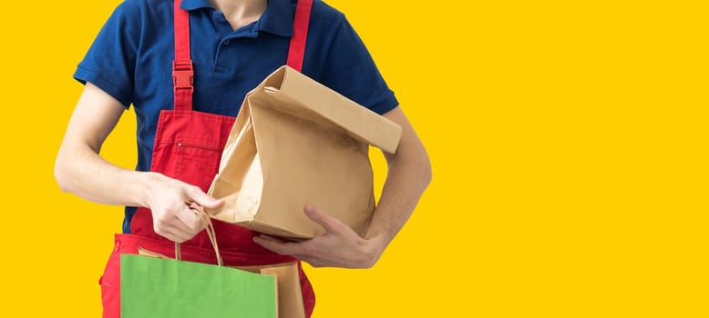 Diverse of paper containers for takeaway food. Delivery man is carrying pizza.