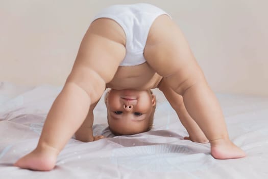 beautiful baby in white panties standing on her head.