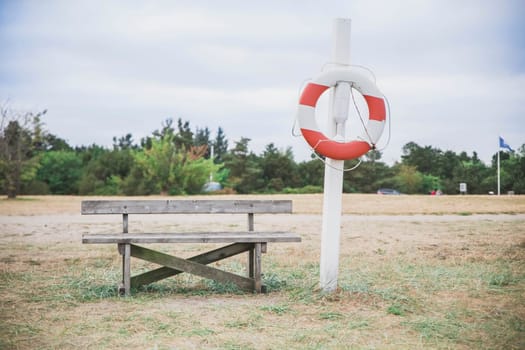 bench and lifebuoy on the shore of the north sea in Denmark.