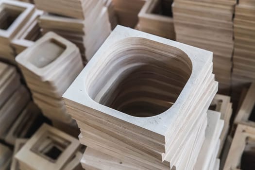 A stack of plywood frames are in the workshop foreground focus.