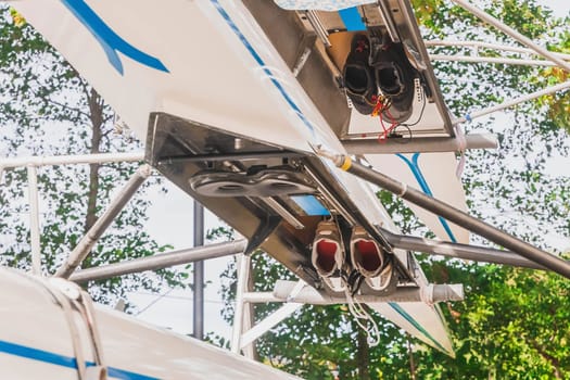 Boats for rowing competition stacked upside down on the shore. Athletes sneakers hidden inside