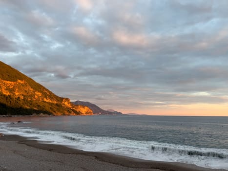 Mountain range in the rays of the setting sun on the seashore. High quality photo