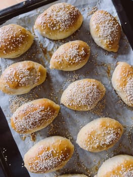 Freshly baked sesame buns lie on a baking sheet. High quality photo