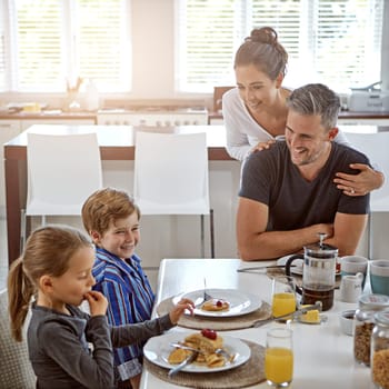 Breakfast isnt complete without pancakes. a family having breakfast together