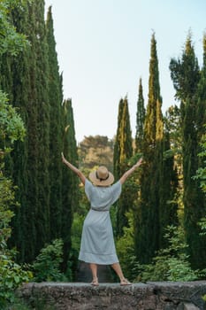 happy woman wearing a fedora hat while standing in the woods.