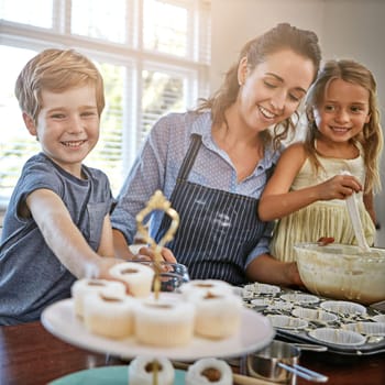 Ill just have one and be on my way. a mother baking in the kitchen with her daughter and son