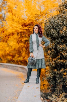 A woman walks outdoors in autumn, enjoys the autumn weather