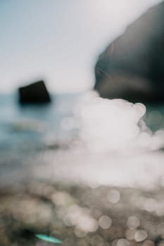 Abstract nature summer or spring ocean sea background. Small waves on water surface in motion blur with bokeh lights from sunrise.