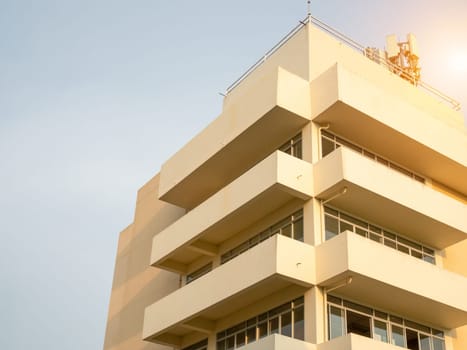 side view of yellow concrete building Intersect the orange sun.