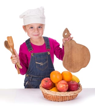 Close-up portrait of a little girl holding fruits and kitchen appliances