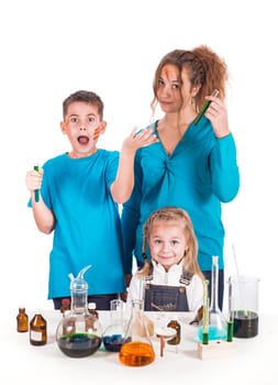 Three children working with chemical liquids at lesson Crazy scientist