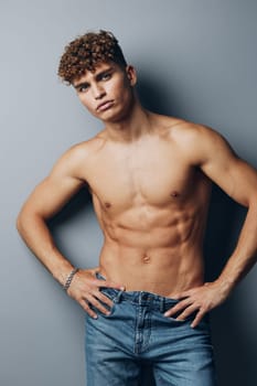 man naked fashion studio male torso standing muscle fitness smile model jeans chest background gray shirtless