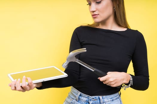 Service center. Laptop Repair. Female screwdriver unscrews laptop bolts on a yellow background