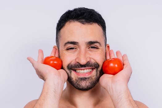 Full isolated studio picture from a young naked man with underwear and tomatoes