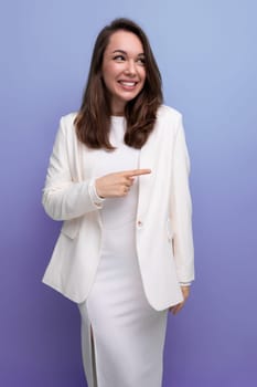 close-up portrait of a smiling european brunette woman with long hair in a white dress and jacket posing on a studio background.