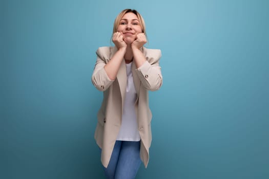 positive blonde young woman in casual style on studio background.