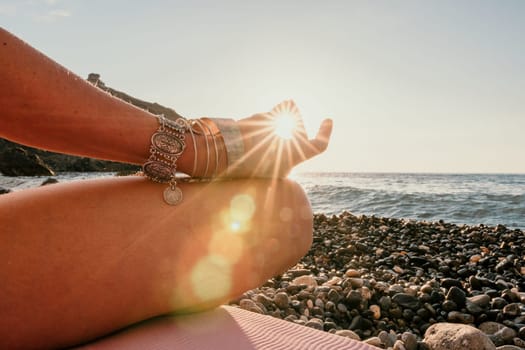 Young woman in swimsuit with long hair practicing stretching outdoors on yoga mat by the sea on a sunny day. Women's yoga fitness pilates routine. Healthy lifestyle, harmony and meditation concept.