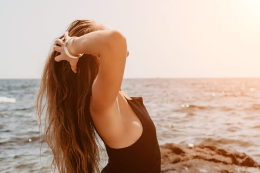 Woman travel sea. Young Happy woman in a long red dress posing on a beach near the sea on background of volcanic rocks, like in Iceland, sharing travel adventure journey