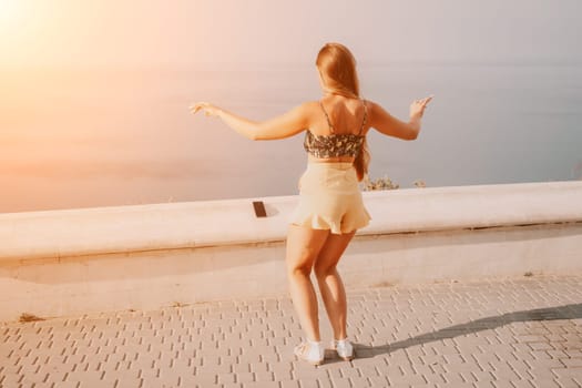 silhouette of a happy woman who dances, spins and raises her hands to the sky. A woman is enjoying a beautiful summer day.