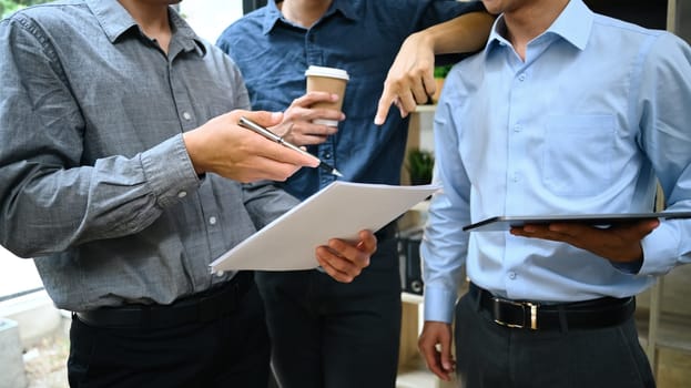 Group of young businessman discussing project results and planning work at office.