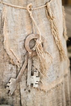 A bunch of old wooden keys hanging on a rope, close-up.