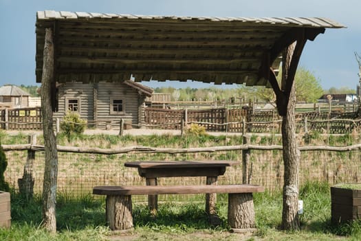 An old wooden gazebo for relaxing in the park. Equipped with wooden tables and benches.