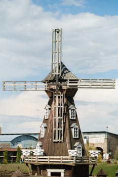 Decorative wooden mill standing outside in summer.