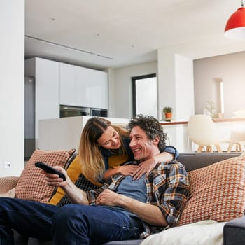 Whats on the agenda for us today. a mature married couple relaxing on the sofa at home