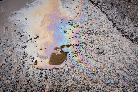 Gasoline stains on asphalt. Gasoline spilled on road. Road in the pits.