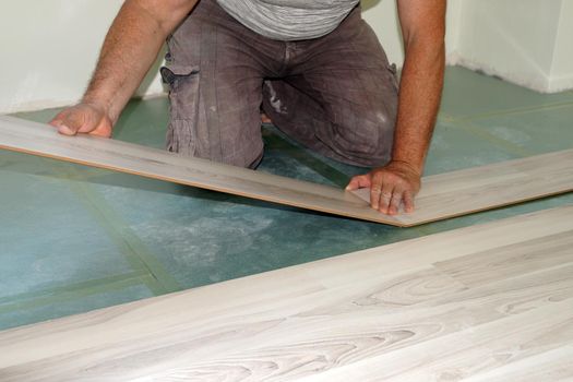 a man is installing a laminate on the floor close up