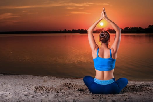 yoga at sunset on the beach. woman doing yoga, performing asanas and enjoying life on the river