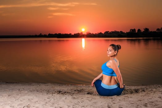 yoga at sunset on the beach. woman doing yoga, performing asanas and enjoying life on the river