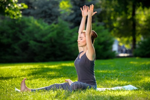 Young fitness woman meditation in a city park.Yoga at sunset in the park. Girl is practicing yoga. Fitness training outdoors. Attractive fitness woman. Workout outdoors. Healthy lifestyle