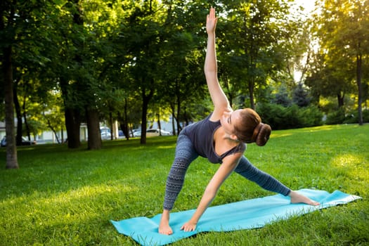 Young fitness woman meditation in a city park.Yoga at sunset in the park. Girl is practicing yoga. Fitness training outdoors. Attractive fitness woman. Workout outdoors. Healthy lifestyle
