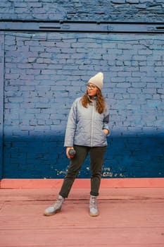 Portrait of a stylish woman in blue jacket with coffee cup. Spring outdoor portrait.