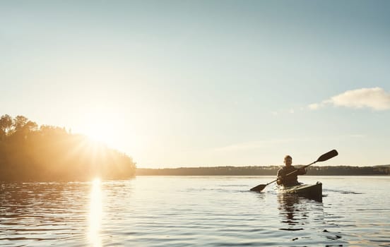 Exploring the outdoors one paddle at a time. a young man kayaking on a lake outdoors