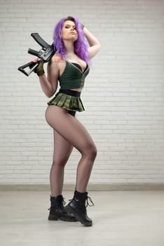 sexy girl with pink hair in a short skirt miliriti with an airsoft gun on a white background of brick wall